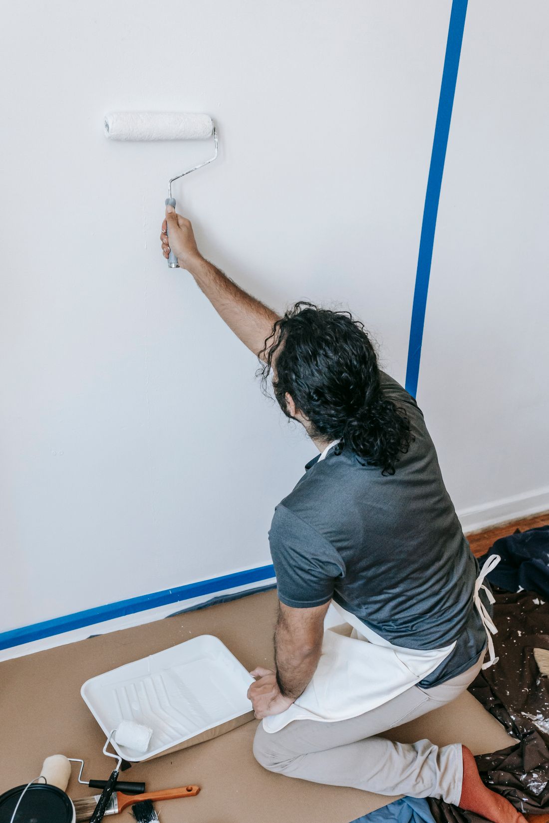 Pintor aplicando pintura a un muro con rodillo